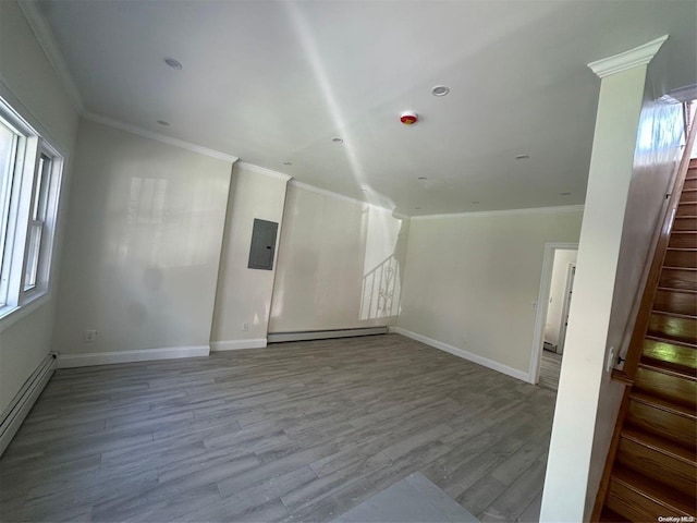 spare room with light wood-type flooring, a wealth of natural light, and a baseboard heating unit