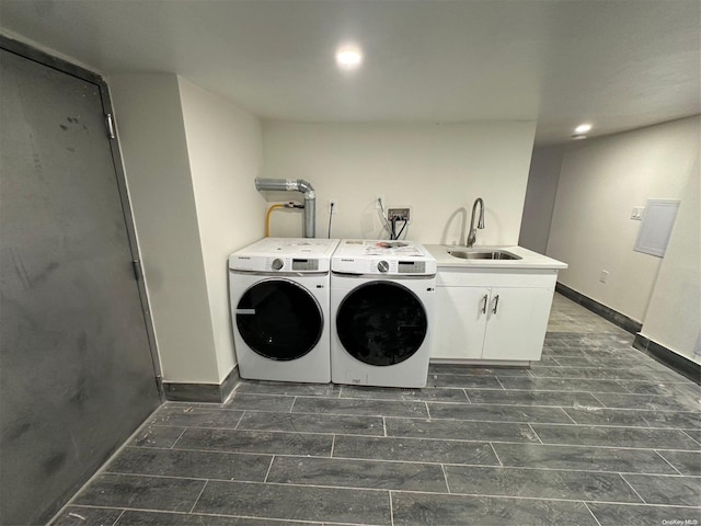 laundry area featuring cabinets, separate washer and dryer, and sink