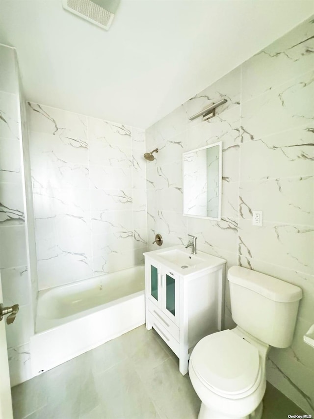 full bathroom featuring tile walls, vanity, tiled shower / bath combo, and toilet