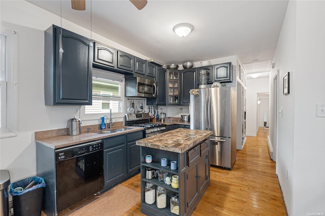 kitchen featuring ceiling fan, sink, a center island, light hardwood / wood-style flooring, and appliances with stainless steel finishes