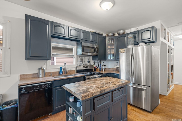 kitchen with sink, a center island, light hardwood / wood-style flooring, blue cabinets, and appliances with stainless steel finishes