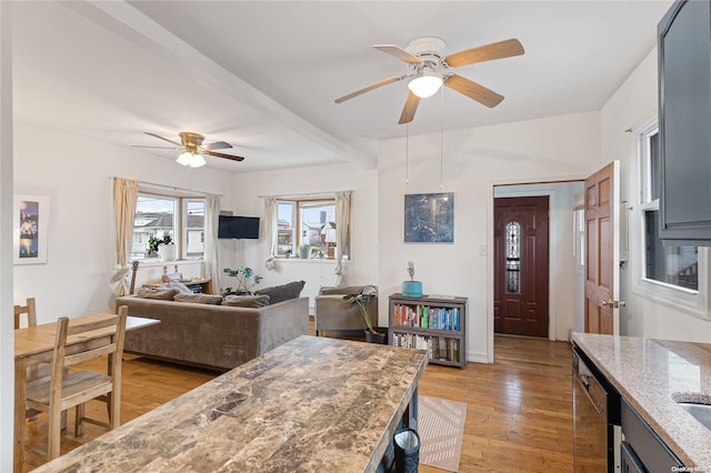 dining room featuring beamed ceiling, ceiling fan, and light hardwood / wood-style floors