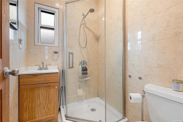 bathroom with vanity, toilet, walk in shower, and tile walls