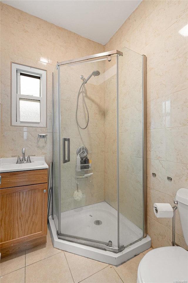 bathroom with tile patterned floors, a shower with door, and tile walls