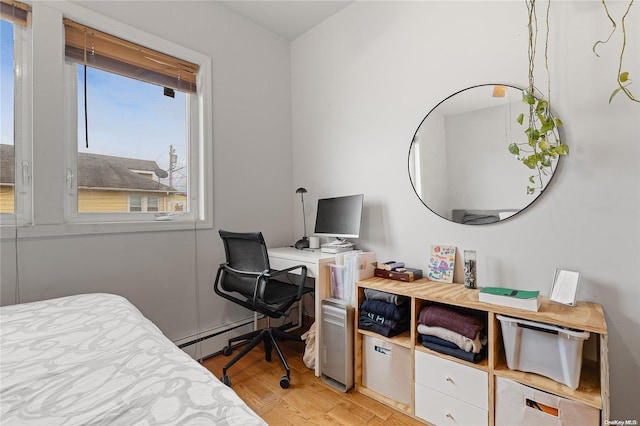 bedroom featuring light wood-type flooring and a baseboard radiator