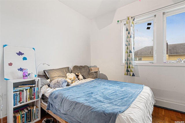 bedroom with a baseboard radiator and dark wood-type flooring