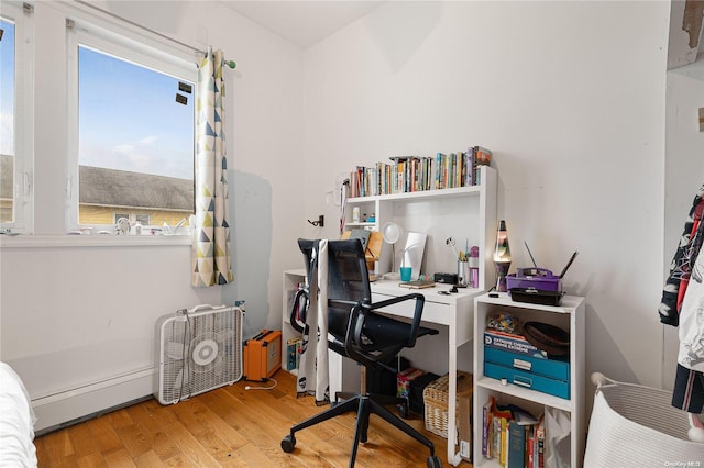 office area with wood-type flooring and a baseboard heating unit