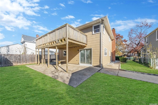 back of property with a lawn, a patio area, and a deck