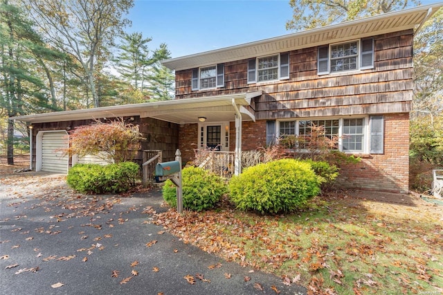 view of property with a porch and a garage