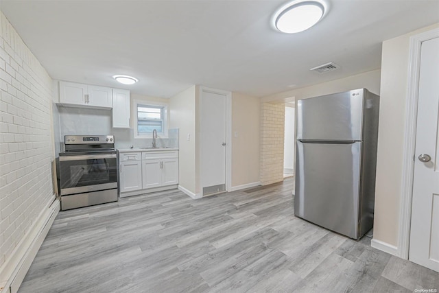 kitchen with white cabinets, stainless steel appliances, brick wall, and light hardwood / wood-style floors