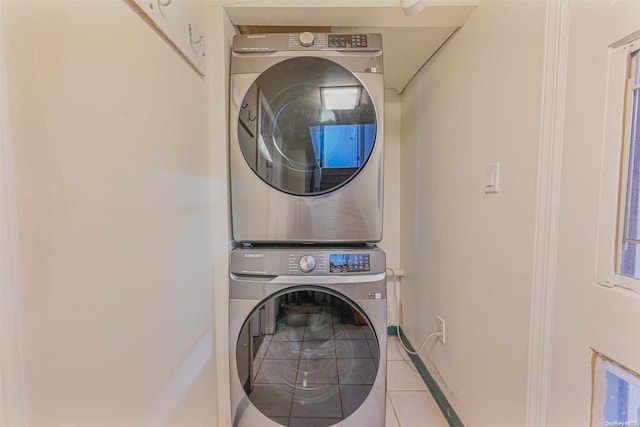 washroom with stacked washing maching and dryer and light tile patterned flooring