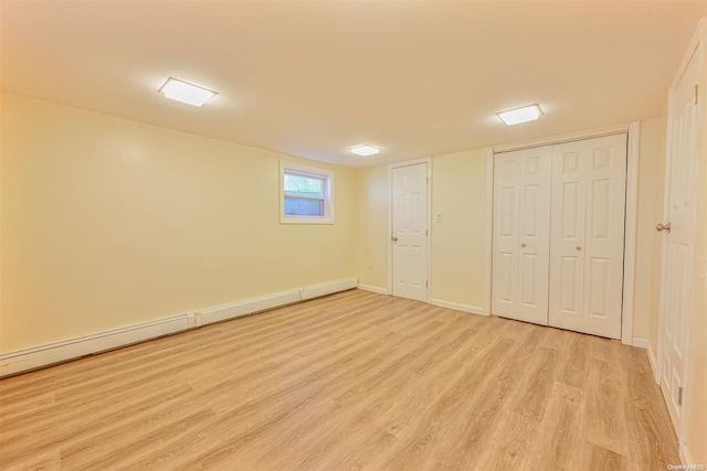 basement featuring baseboard heating and light wood-type flooring