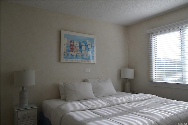 bedroom with multiple windows and a textured ceiling