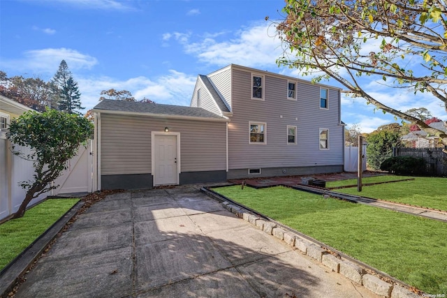 rear view of property featuring a lawn and a patio area