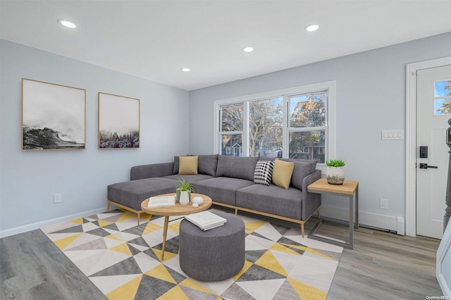 living room with light wood-type flooring and a baseboard radiator