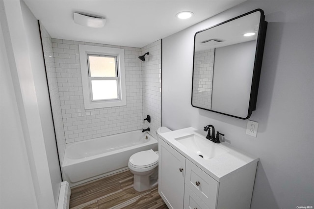 full bathroom with toilet, vanity, tiled shower / bath combo, and hardwood / wood-style flooring