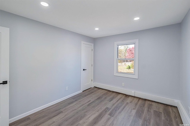 spare room with light hardwood / wood-style floors and a baseboard heating unit