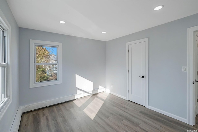 spare room featuring hardwood / wood-style floors and baseboard heating