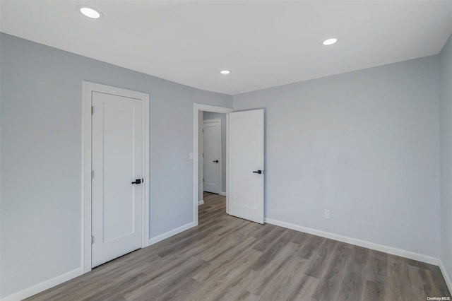 unfurnished bedroom with light hardwood / wood-style flooring and a closet