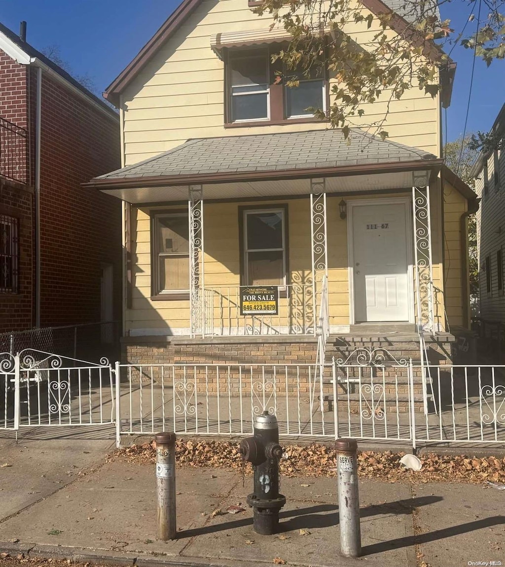 111-67 43rd Ave, Corona, NY 11368 - view of front of property with a porch, roof with shingles, and a fenced front yard