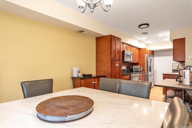 dining room with hardwood / wood-style floors and a chandelier