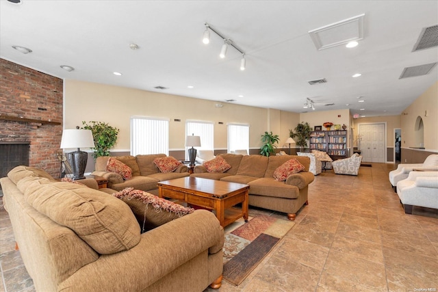 living room with rail lighting and a brick fireplace