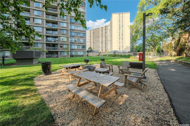 view of property's community with a yard and an outdoor fire pit