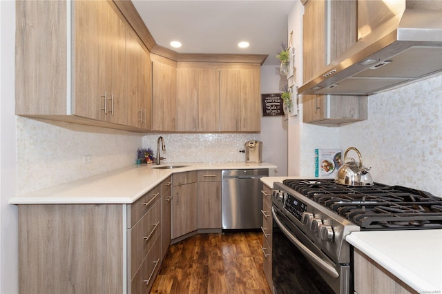 kitchen with sink, wall chimney exhaust hood, dark hardwood / wood-style floors, light brown cabinetry, and appliances with stainless steel finishes