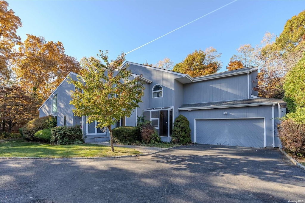 view of front of property featuring a garage and a front lawn