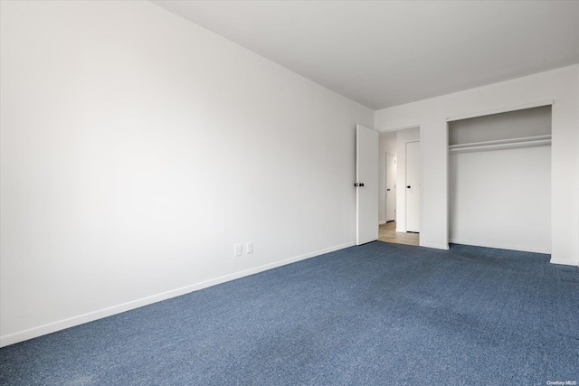 unfurnished bedroom featuring dark colored carpet and a closet