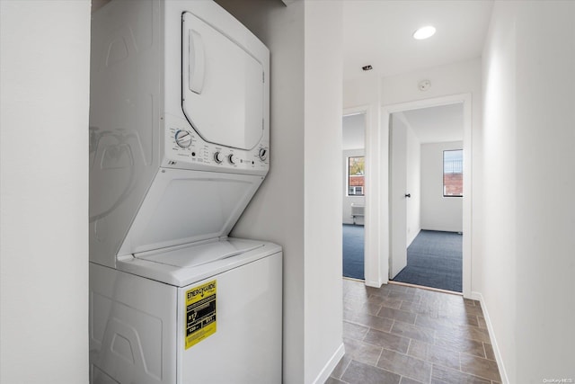 washroom with carpet flooring and stacked washer and dryer