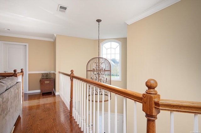 hallway featuring a notable chandelier, dark hardwood / wood-style flooring, and ornamental molding