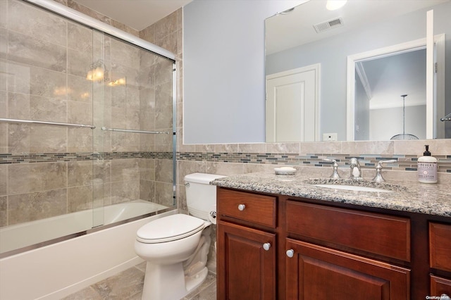 full bathroom with tile patterned flooring, enclosed tub / shower combo, toilet, vanity, and tile walls