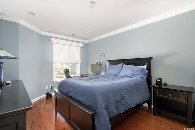 bedroom with dark hardwood / wood-style floors and ornamental molding