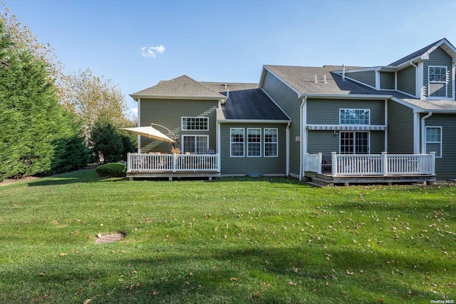 back of property featuring a lawn and a deck