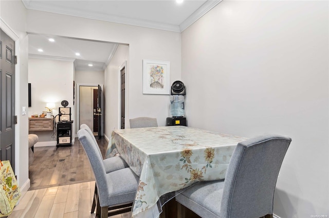 dining space featuring hardwood / wood-style floors and ornamental molding