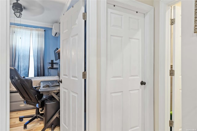 office area with crown molding, ceiling fan, a wall mounted air conditioner, and hardwood / wood-style flooring