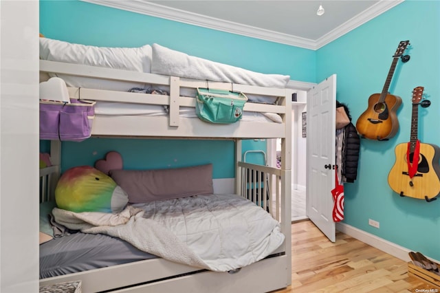 bedroom with light hardwood / wood-style floors and ornamental molding