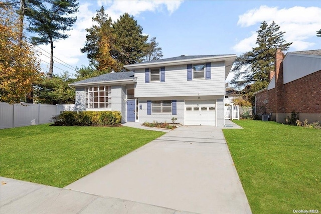 view of front facade with a front yard, a garage, and cooling unit