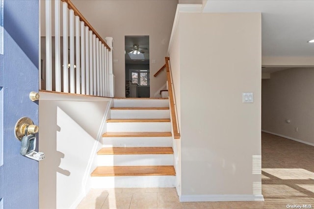 staircase with tile patterned floors and ceiling fan