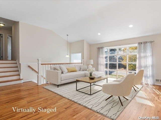 living room featuring vaulted ceiling and light hardwood / wood-style flooring