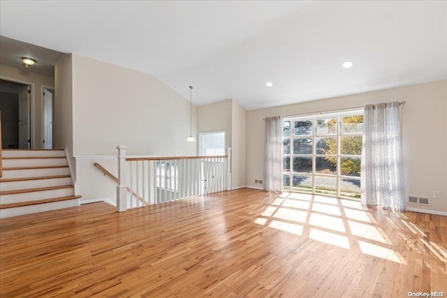 unfurnished room with lofted ceiling and light hardwood / wood-style flooring