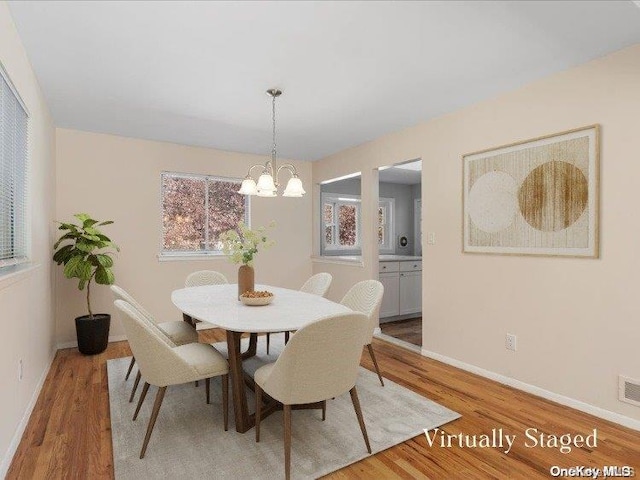 dining room featuring hardwood / wood-style floors and an inviting chandelier