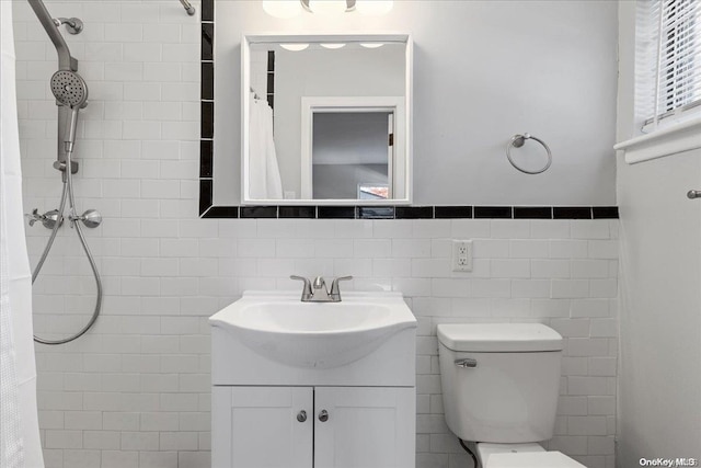 bathroom with vanity, a shower with shower curtain, tile walls, and toilet