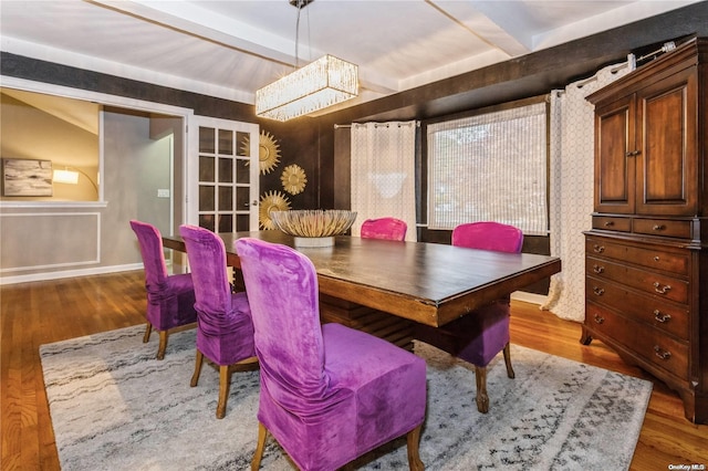 dining area with beam ceiling and hardwood / wood-style flooring