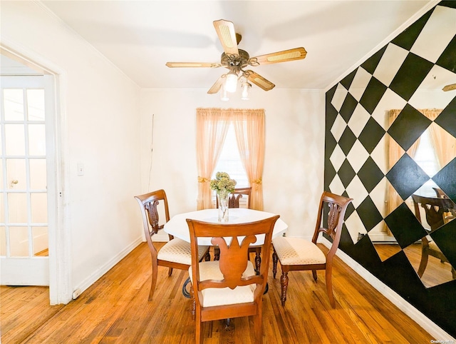 dining area with wood-type flooring, ceiling fan, and ornamental molding