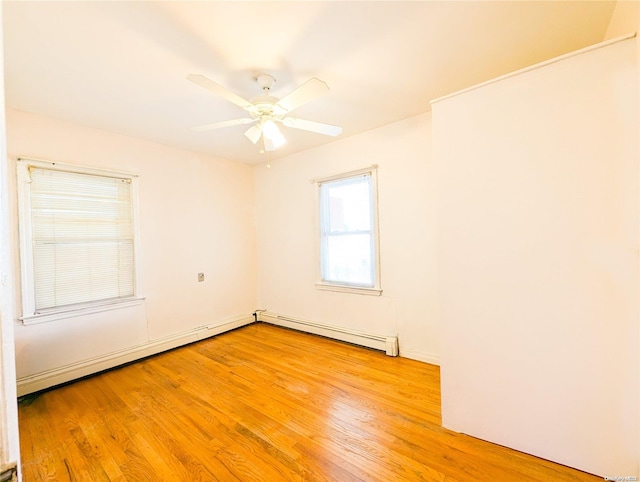 spare room featuring ceiling fan, a baseboard radiator, and light hardwood / wood-style flooring