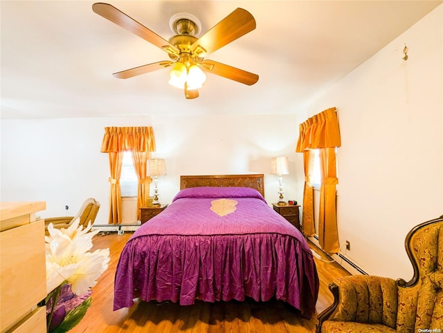 bedroom with hardwood / wood-style flooring, ceiling fan, and a baseboard radiator