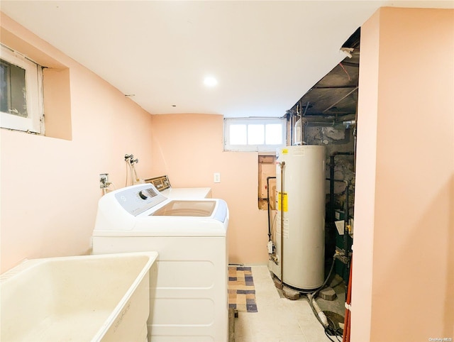 clothes washing area featuring gas water heater, independent washer and dryer, and sink