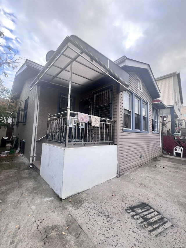 view of side of home featuring a carport and covered porch